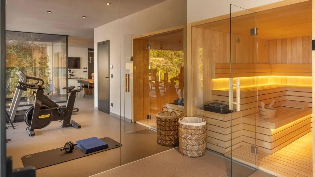 Sauna with glass front and gym equipment at Villa Atreeum