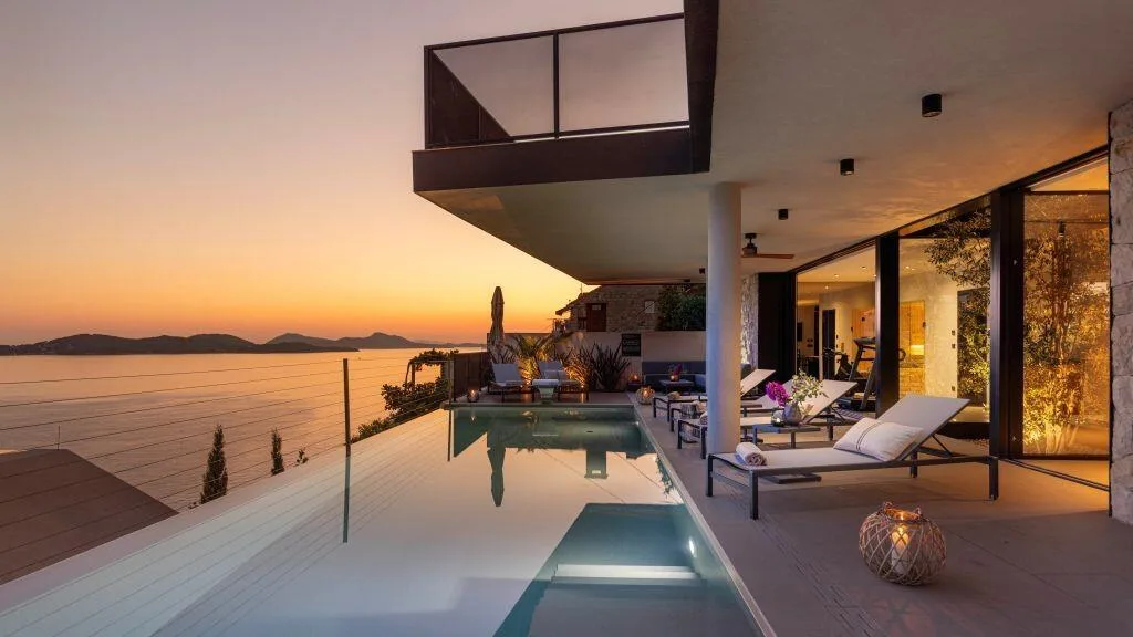 Pool terrace with sun loungers at dusk at Villa Atreeum