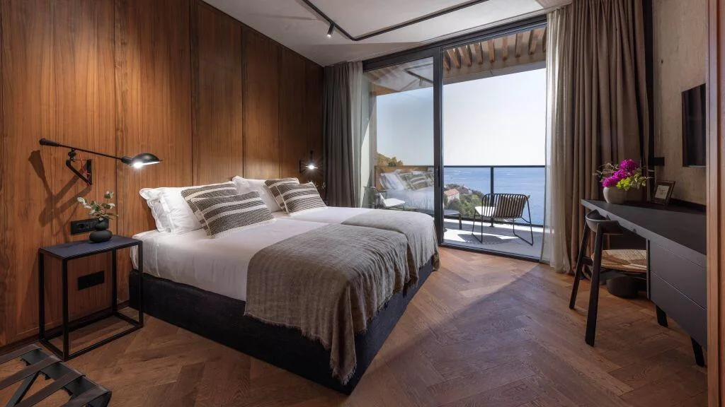 Bedroom with king-size bed, desk and sea-view balcony at Villa Atreeum