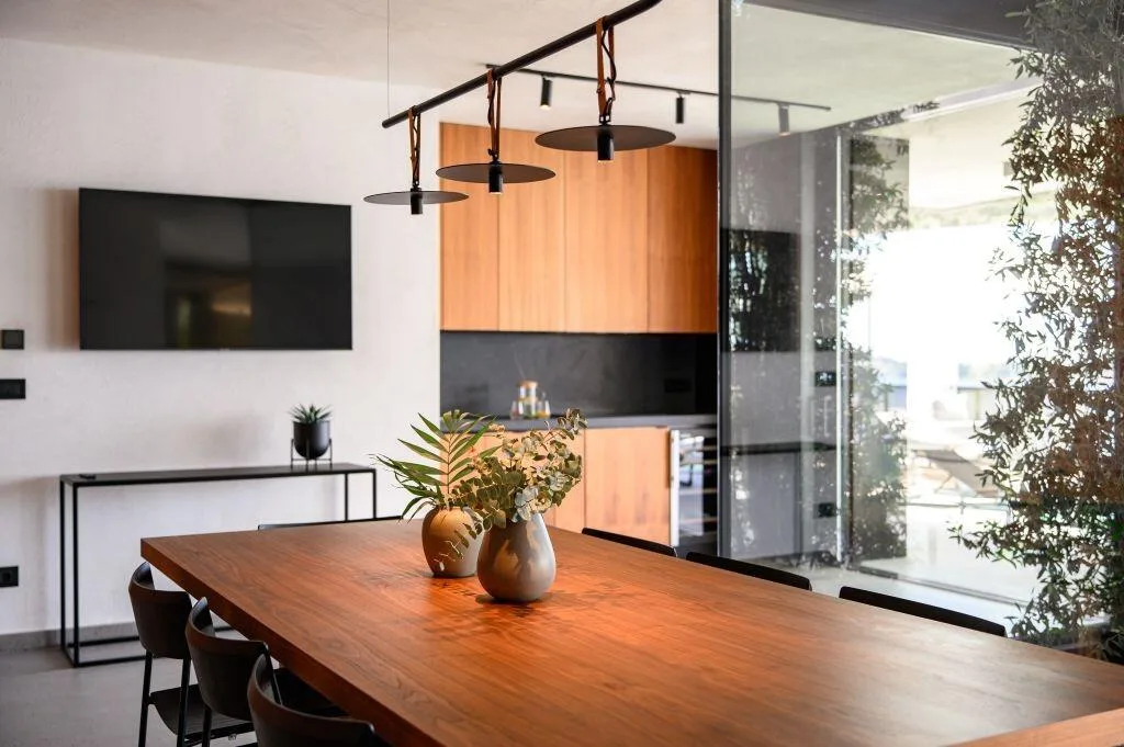 Wooden dining table and kitchen with copper details at Villa Atreeum