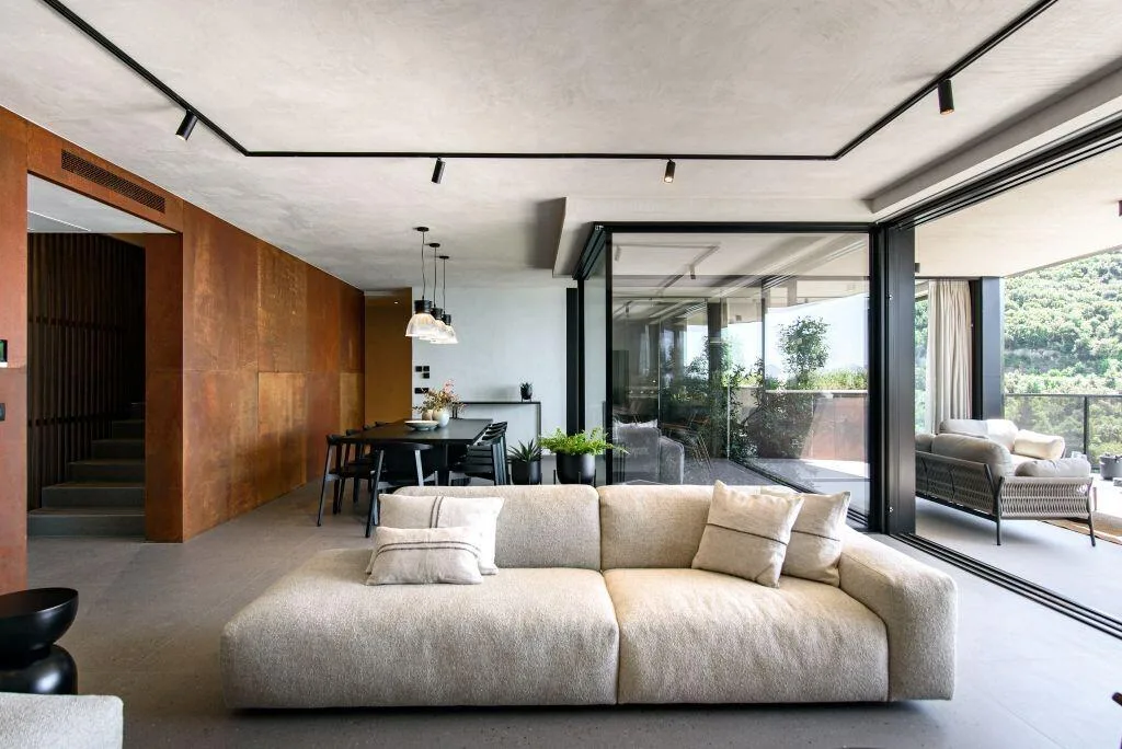 Open-plan living room with beige sofa and terrace doors at Villa Atreeum
