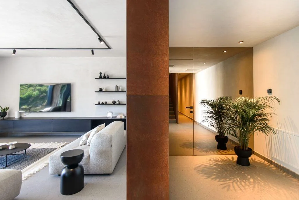 Living area with white sofa, plants and wooden wall at Villa Atreeum