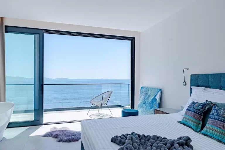 Bedroom with king-size bed and floor-to-ceiling sea view at Villa Sansarea