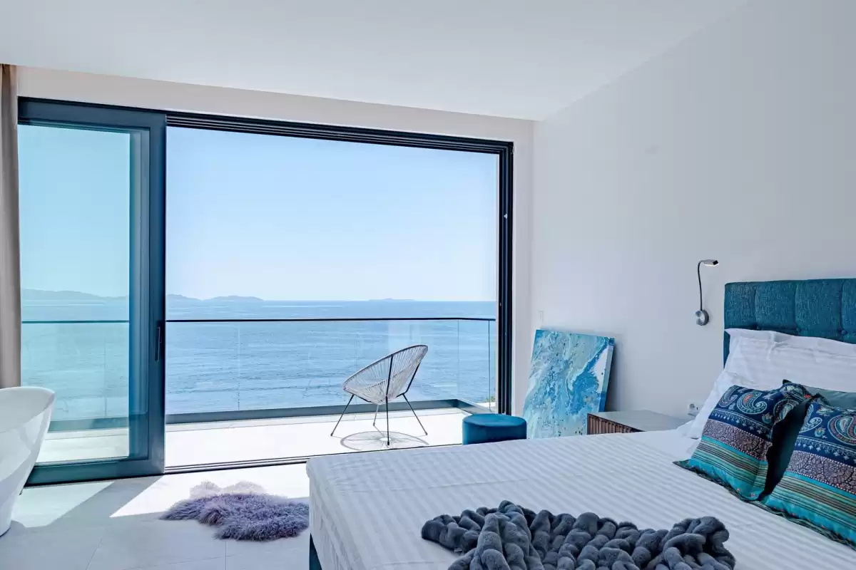 Bedroom with king-size bed and floor-to-ceiling sea view at Villa Sansarea
