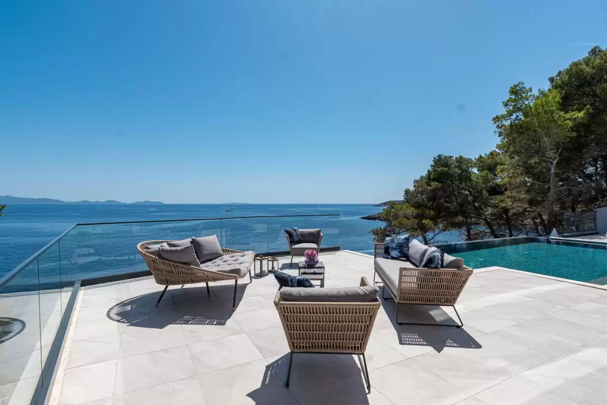 Outdoor lounge with sofas beside the infinity pool at Villa Sansarea