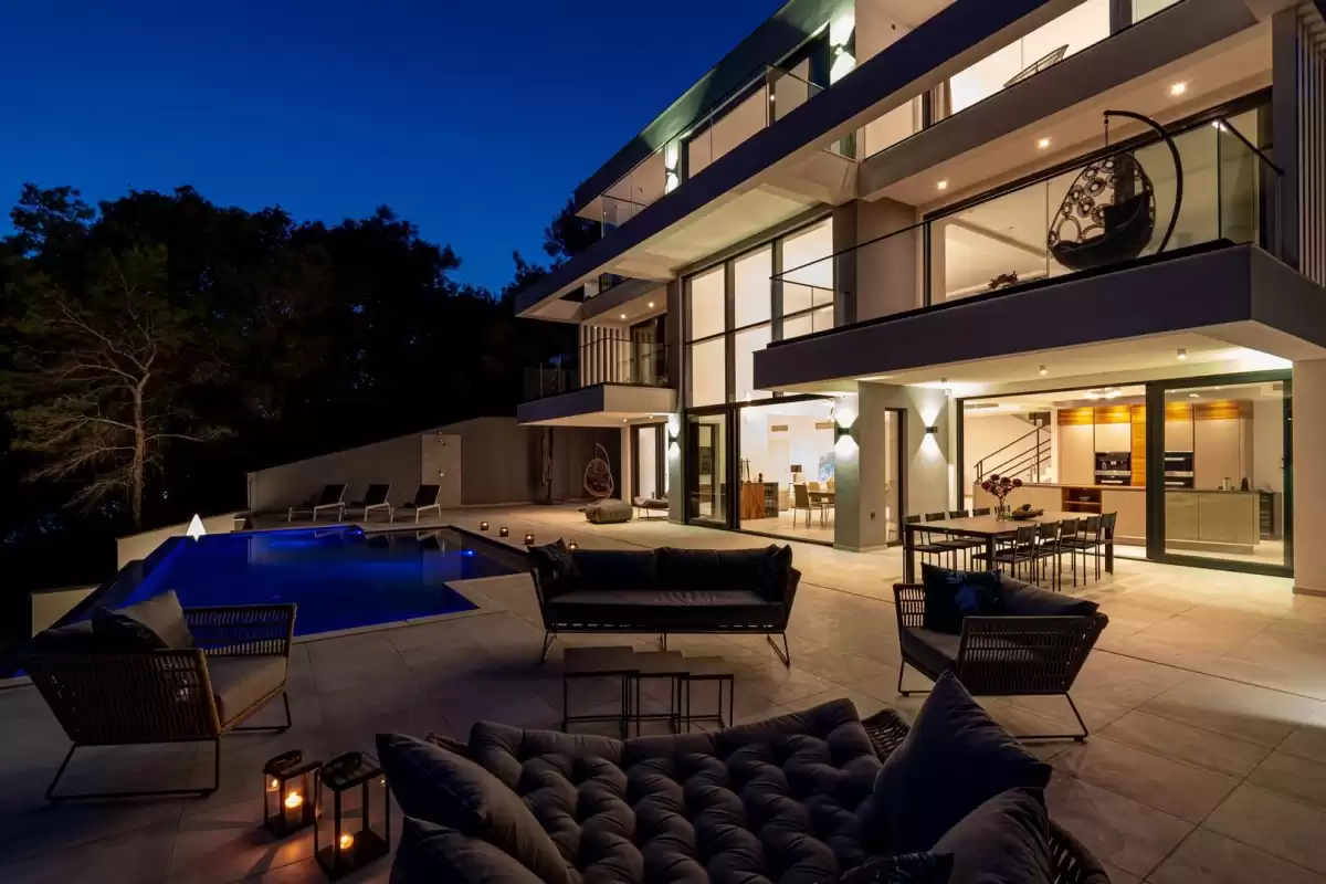 Illuminated terrace and outdoor lounge at night at Villa Sansarea