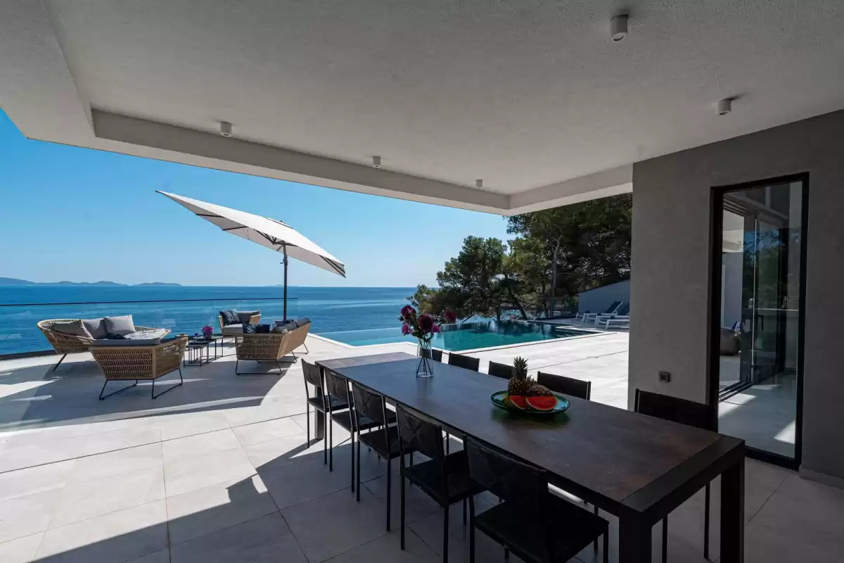 Outdoor dining table for twelve with sea views at Villa Sansarea
