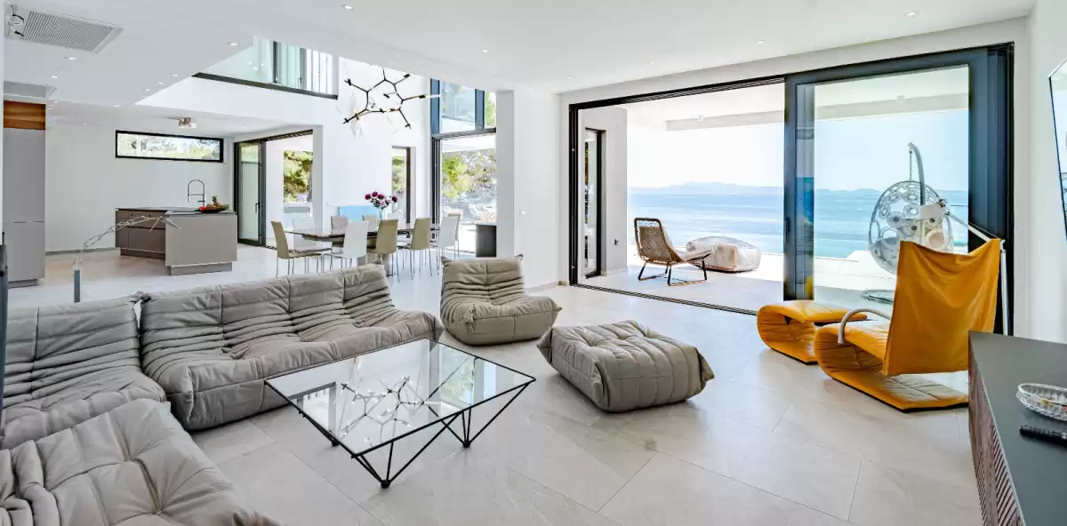 Open-plan living room with designer sofas and sea views at Villa Sansarea