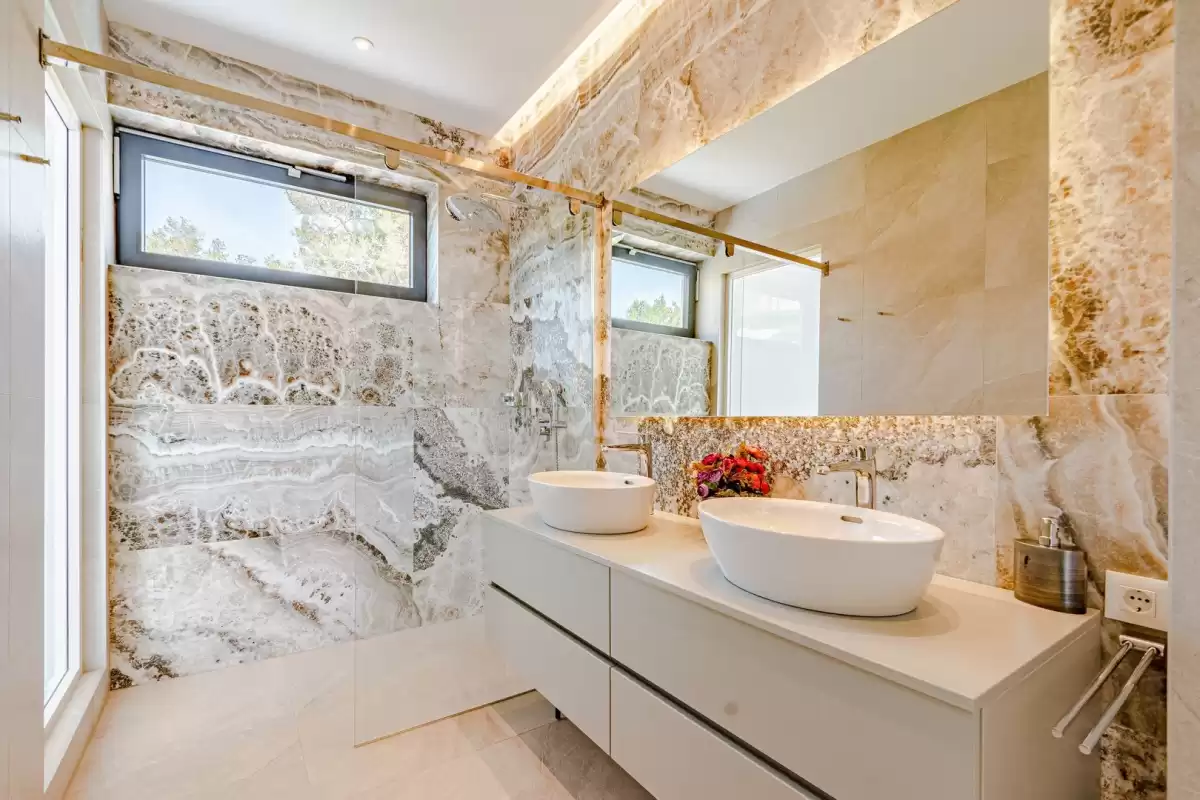 Marble bathroom with vessel basin and illuminated mirror at Villa Sansarea