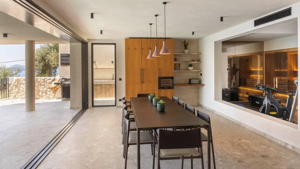 Cuisson élégante et table à manger avec vue sur la salle de sport et la sauna à Villa Eleven