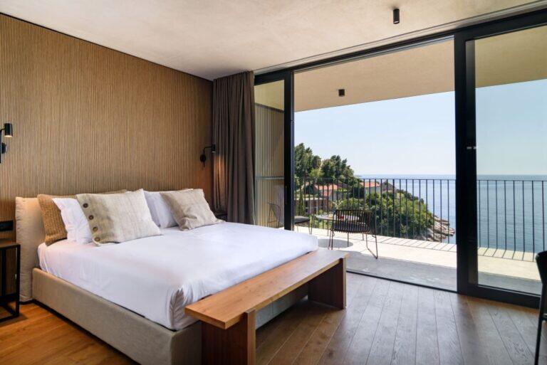 Schlafzimmer mit Kingsize-Bett und Glasfronten zu einem Balkon mit Meerblick in der Villa Eleven