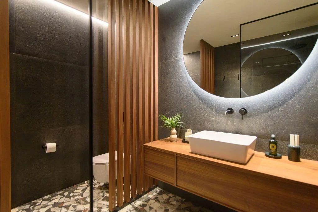 Salle de bains avec miroir rond rétroéclairé et vanité en bois à Villa Eleven, Zaton