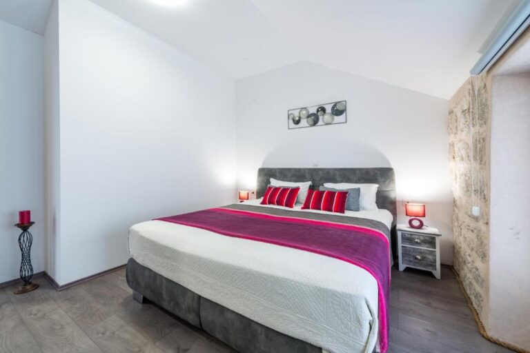 Schlafzimmer mit Doppelbett und Steinmauer im House Brenum