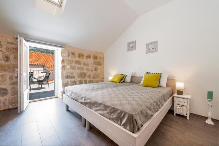 Schlafzimmer mit Doppelbett und Balkontür im House Brenum