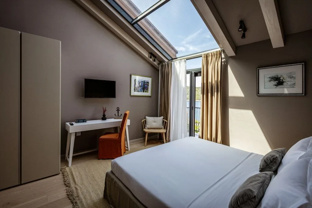 Attic bedroom with king-size bed and skylight at Villa Sol