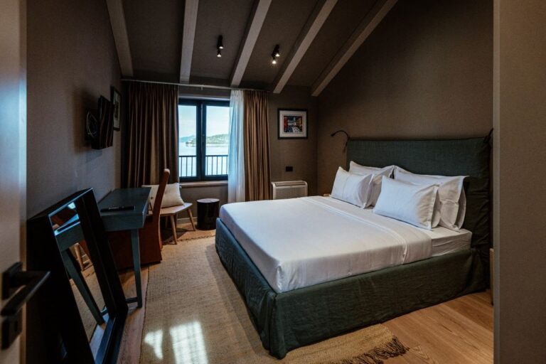 Schlafzimmer mit Kingsize-Bett und Schreibtisch unter dem Deckenbalken im Villa Sol