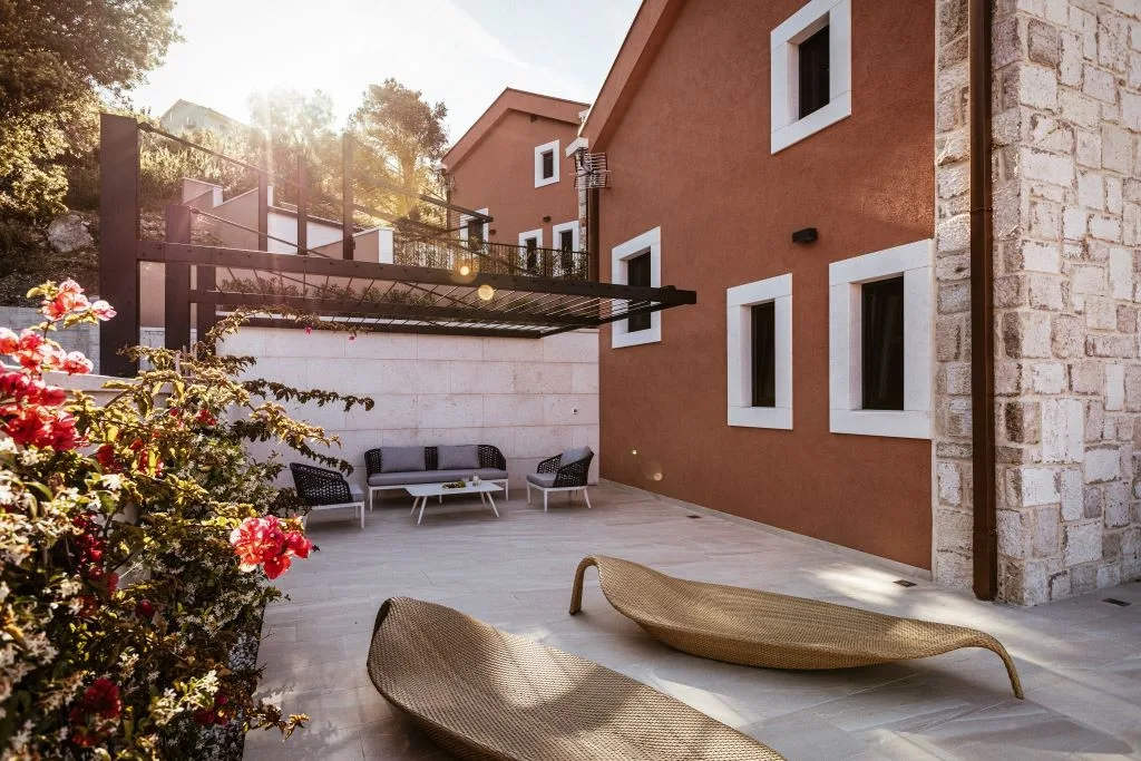 Courtyard terrace with outdoor lounge and flowers at Villa Sol, Slano