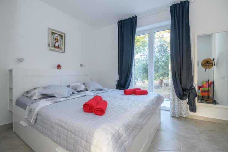 Schlafzimmer mit Queensize-Bett und Garten-Tür an der Villa K in Konavle