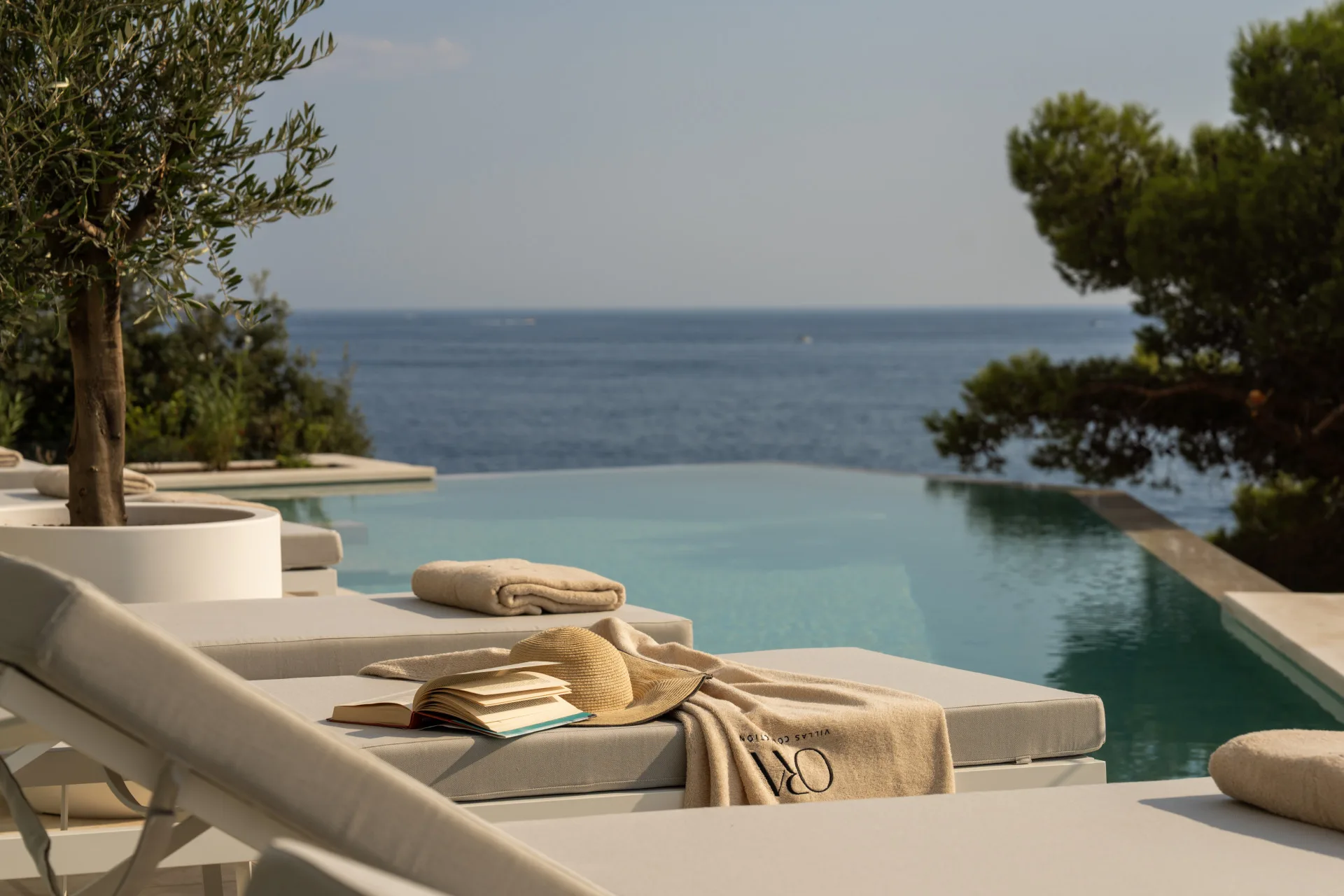 Heated infinity pool with sun loungers and olive tree overlooking the sea at Villa Klara, Štikovica