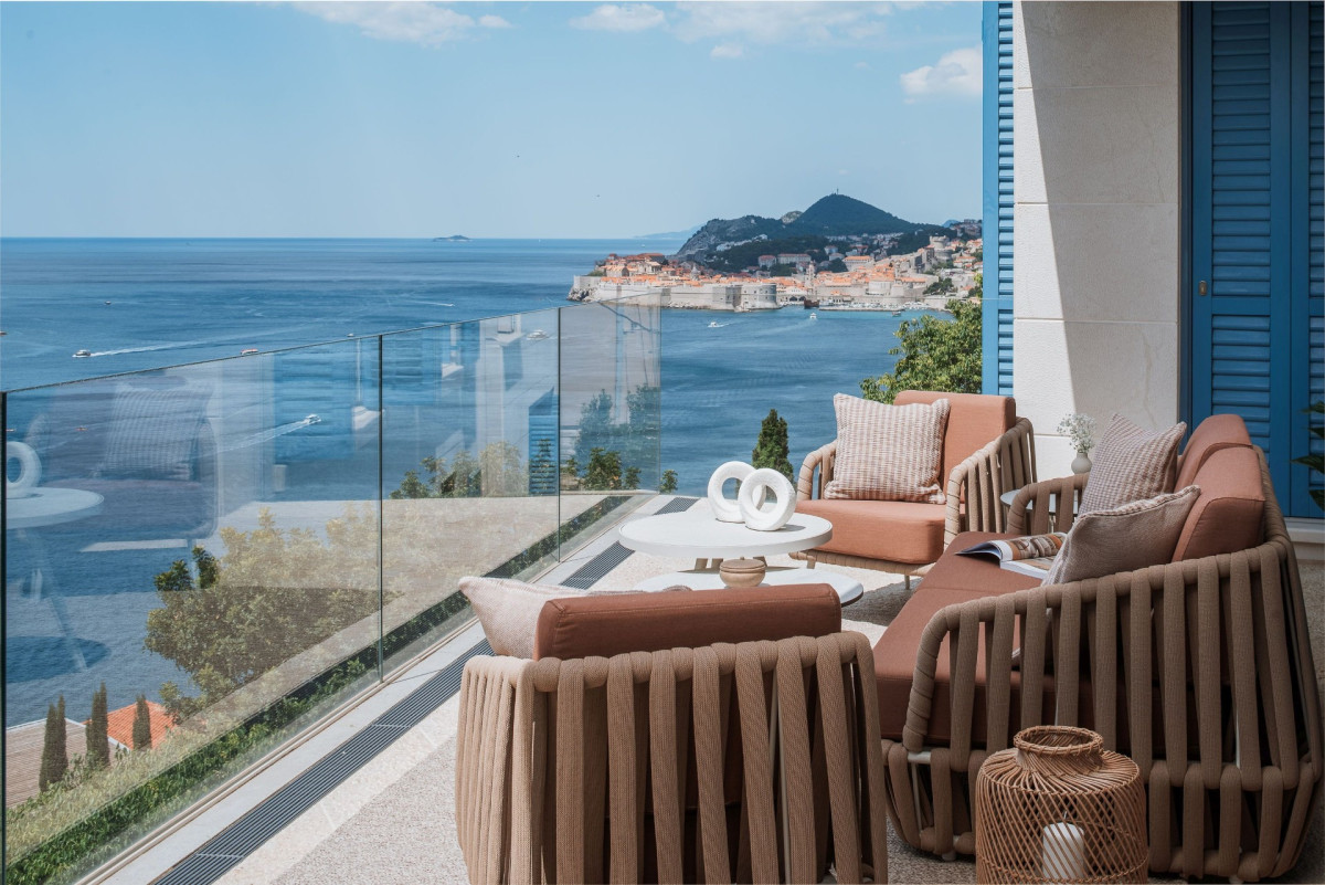 Rattan-Sofas im Garten der Villa Blazia mit Glasgeländer und Blick auf das Meer und die Altstadt von Dubrovnik