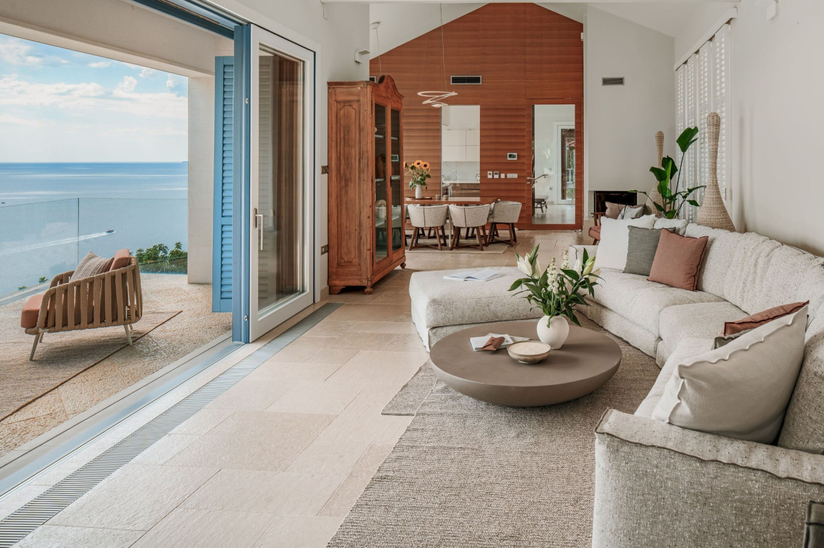 Wohnzimmer in der Villa Blazia mit Sofa, Couchtisch und schiebbaren Glastüren mit Meerblick
