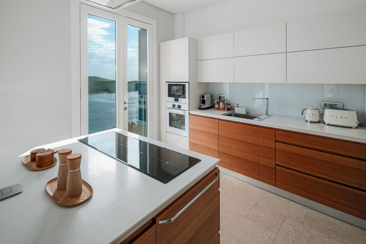 Moderne Küche im Villa Blazia mit zentralem Inselbereich, Induktionskochfeld und Holztischen