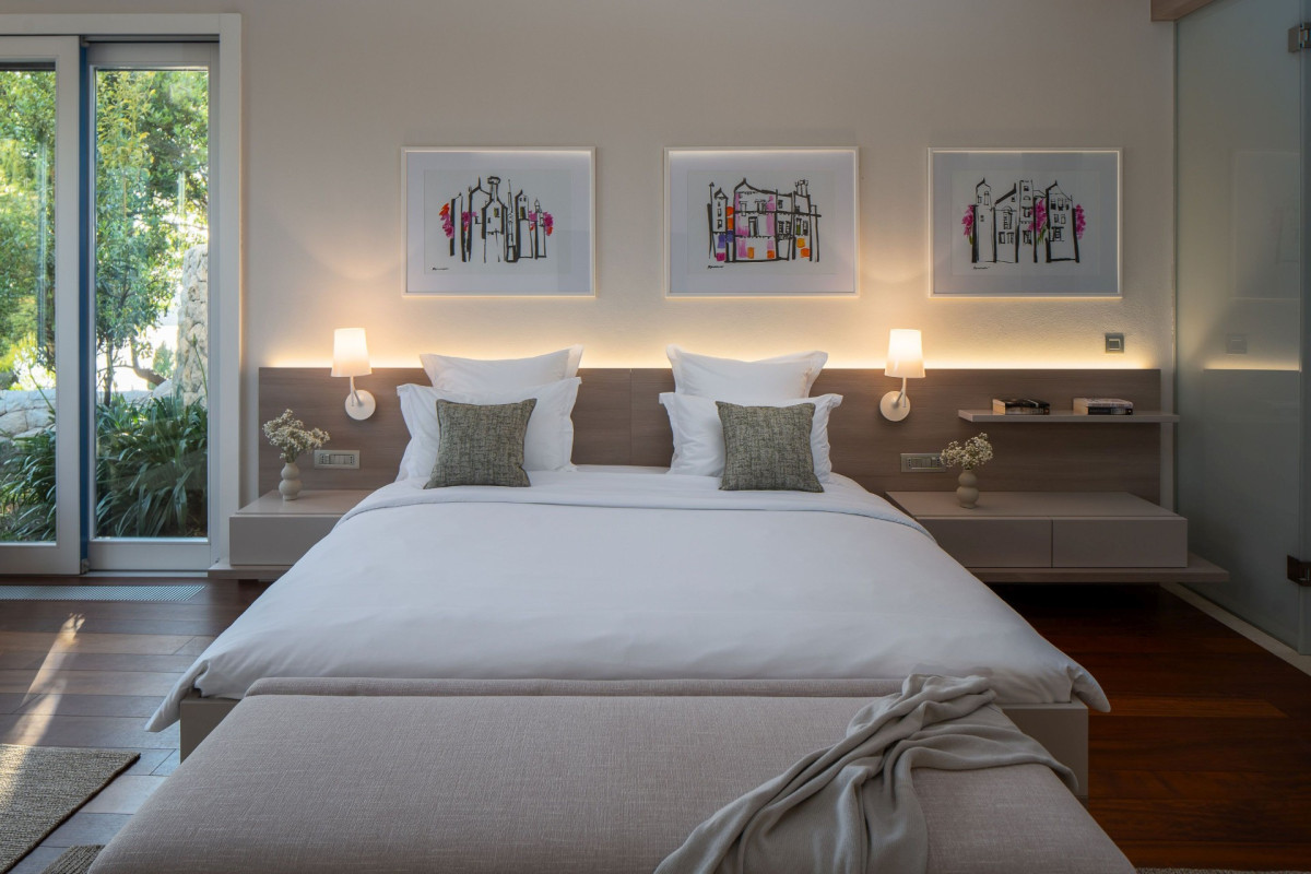 Eleganter Schlafzimmer im Villa Blazia mit einem Doppelbett, weichen Nachttischenleuchten und kunstvollen Bildern