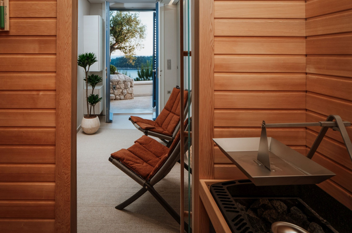 Wellnessbereich mit Holztäfelungen in der Villa Blazia mit Sauna und orangefarbenen Liegestühlen