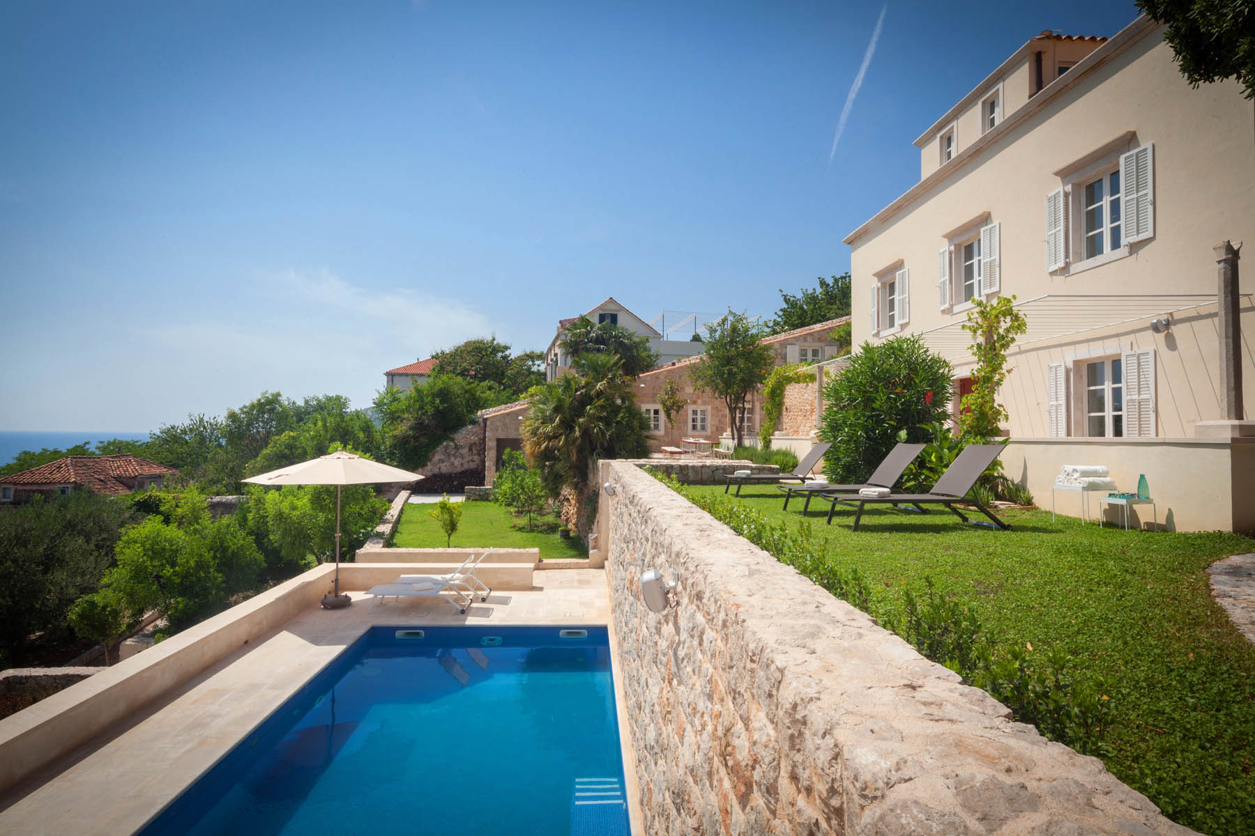 Villa Oasis in Dubrovnik – historic stone villa with private pool, garden lawn and sun loungers above the sea