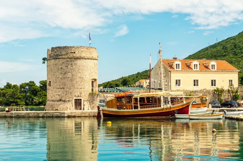 Medieval stone tower and traditional wooden boat in the harbour of Mali Ston on the Pelješac peninsula