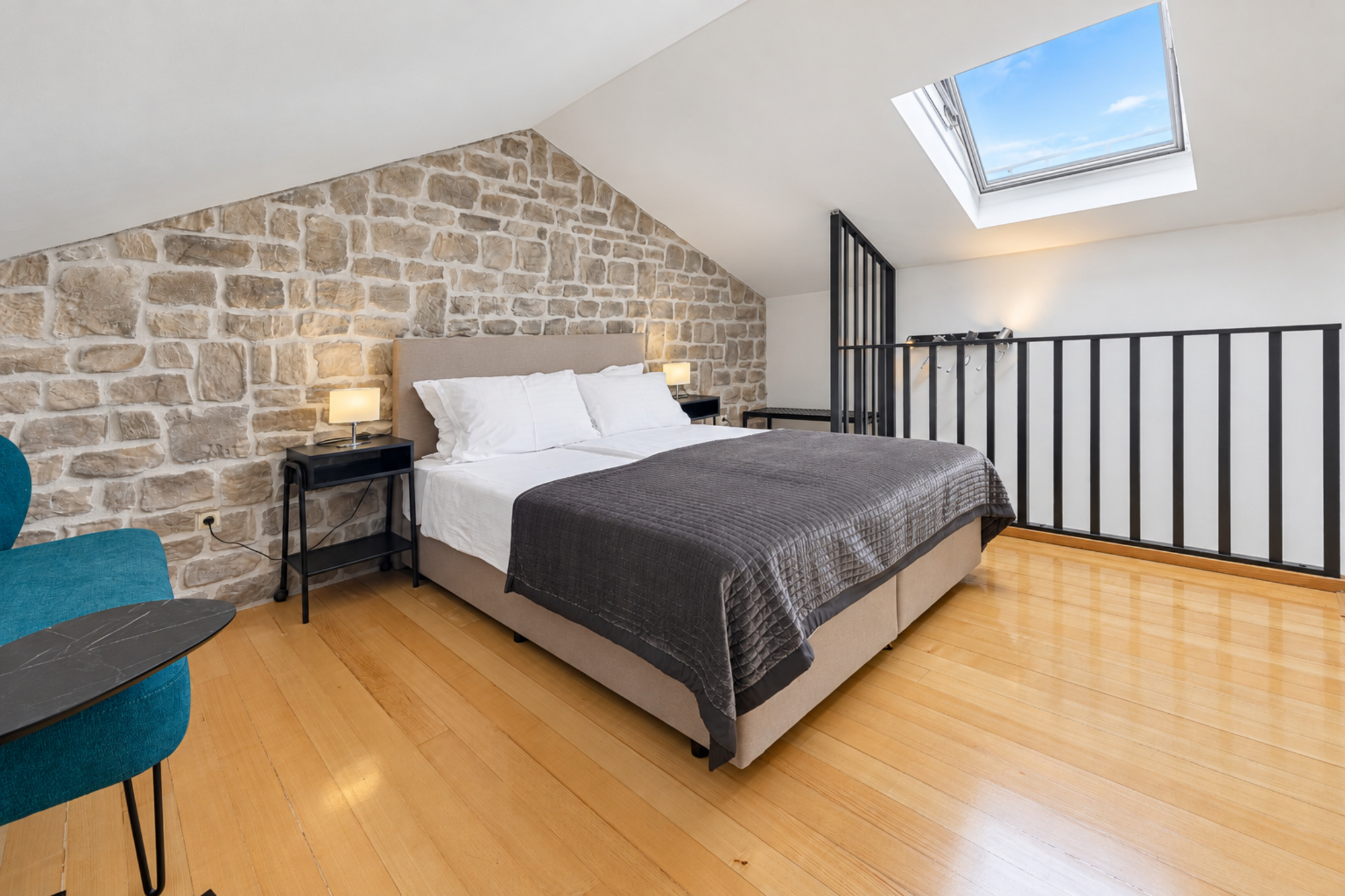 Attic-Schlafzimmer mit Kingsize-Bett, Deckenlüftung und freiliegender Steinwand im Noah House in Zaton bei Dubrovnik