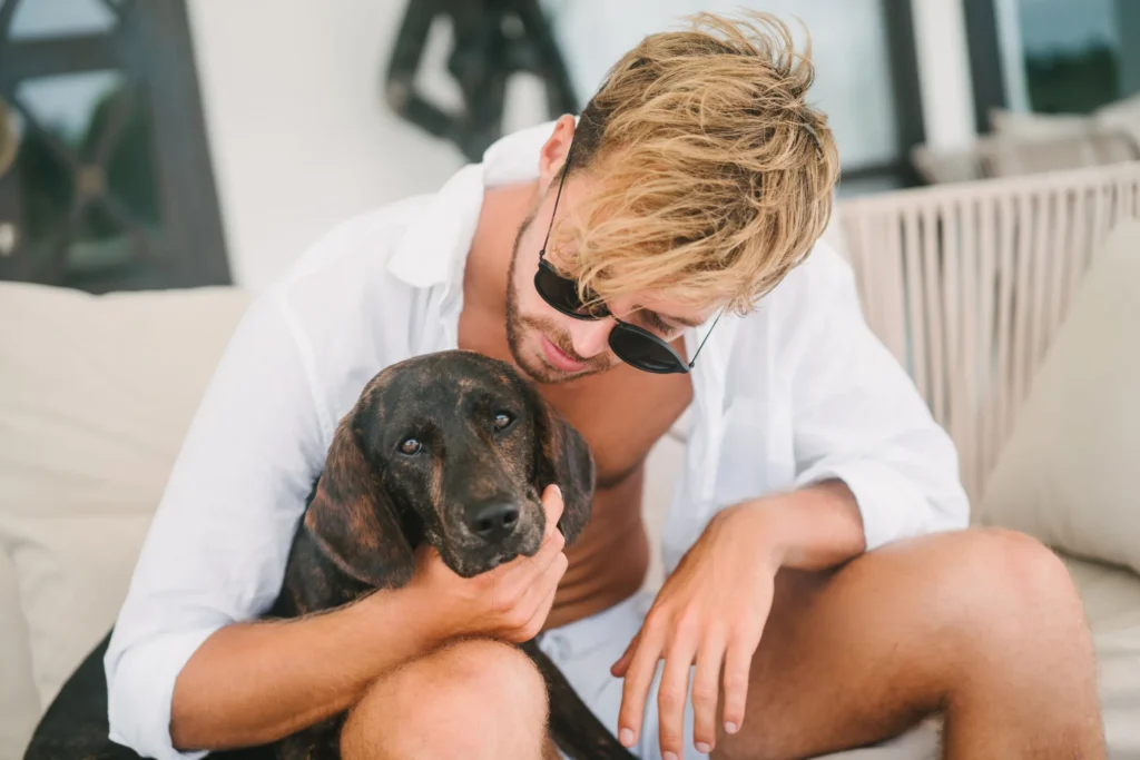 Traveller cuddling his dog on a terrace sofa at a pet-friendly villa near Dubrovnik