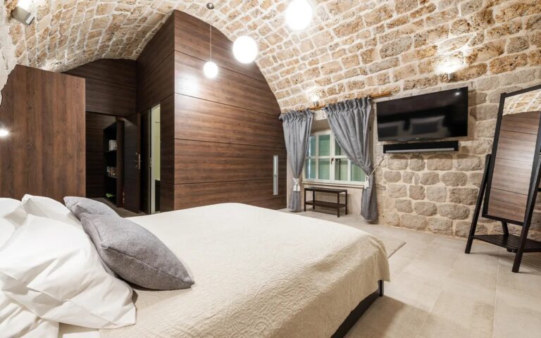 Schlafzimmer mit Kingsize-Bett unter einem gewölbten Steildach in der Villa Carpe Diem