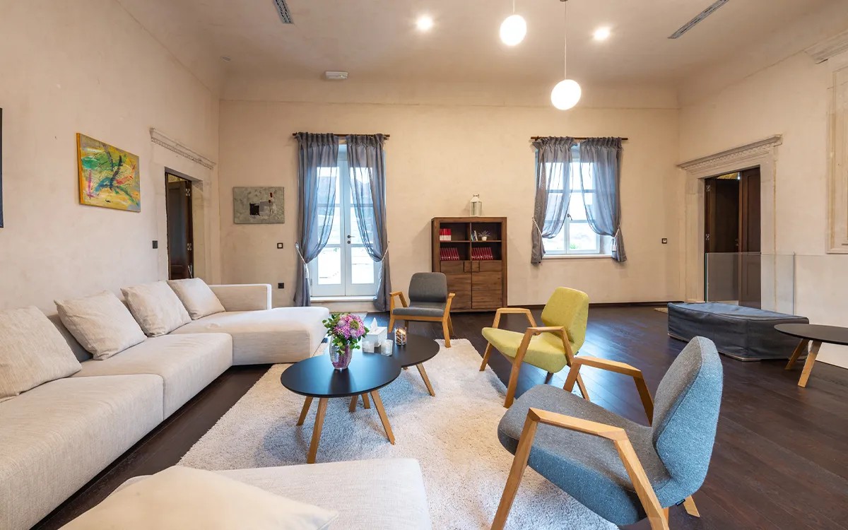 Helles Wohnzimmer mit Ecksofa und Sesseln in der Villa Carpe Diem