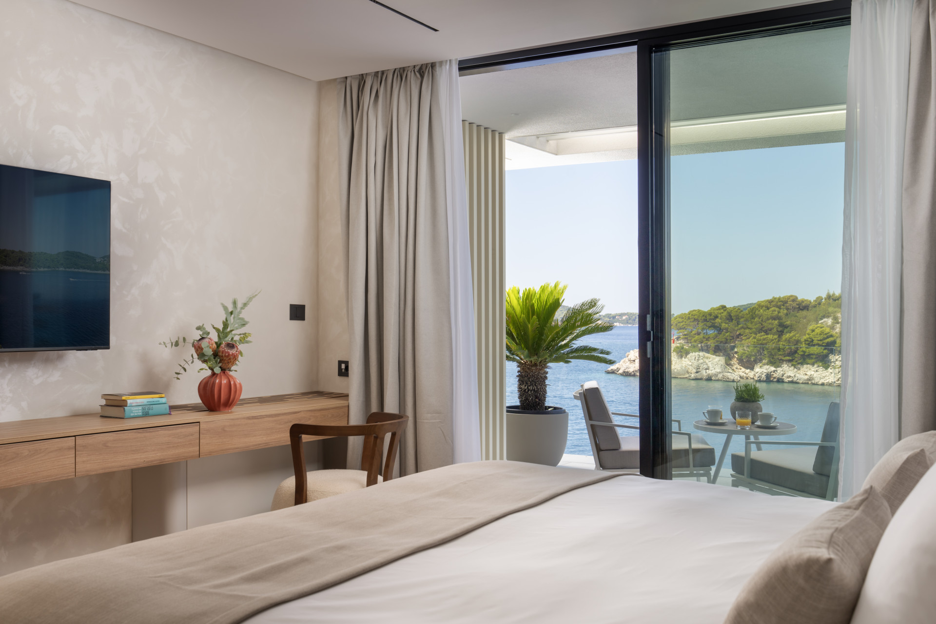 Schlafzimmer mit Schreibtisch und Balkon mit Frühstückstisch mit Blick auf die Bucht von Villa Klara