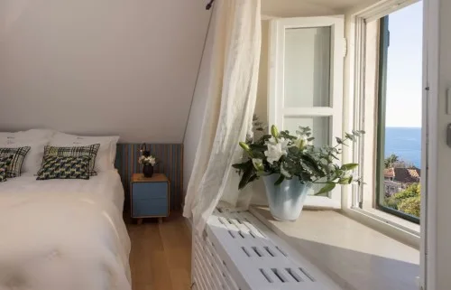 Bedroom with king-size bed and open window overlooking the sea in the annex of Villa La Rose, Dubrovnik