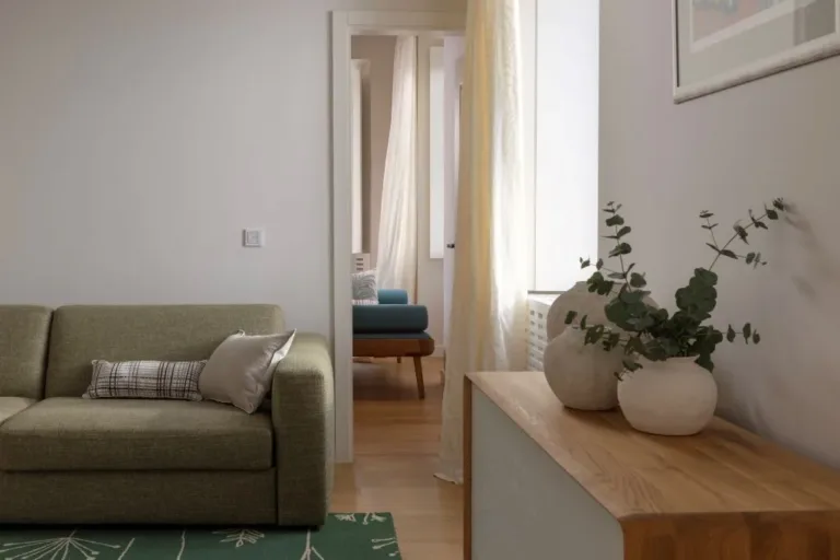 Room with green pull-out sofa and wooden sideboard at Villa La Rose
