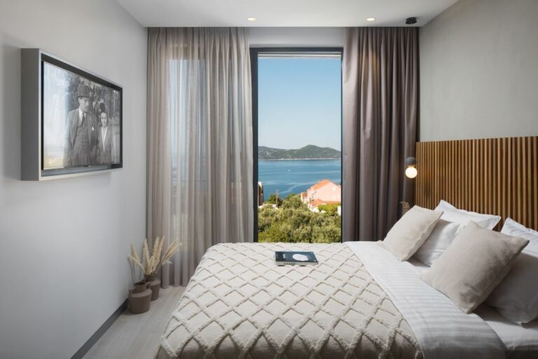 Schlafzimmer mit Kingsize-Bett und bodentiefer Fensterfront mit Meerblick in der Villa Ó in Orašac