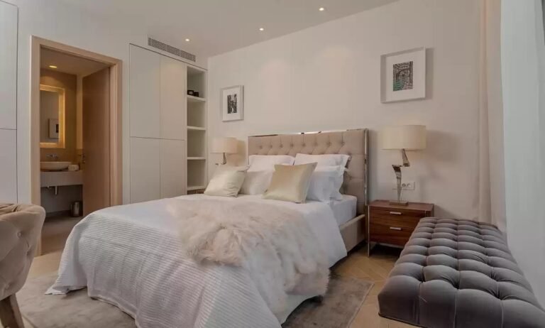 Bedroom with upholstered double bed and en-suite bathroom at Villa Opus