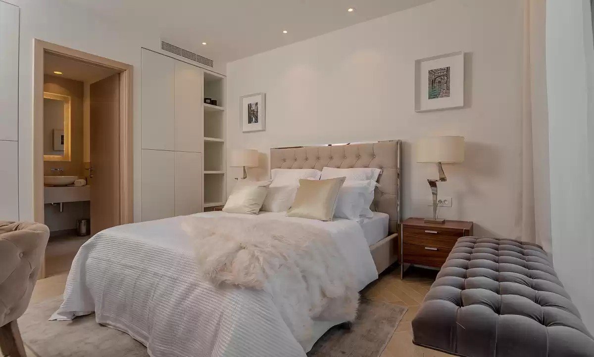 Bedroom with upholstered double bed and en-suite bathroom at Villa Opus