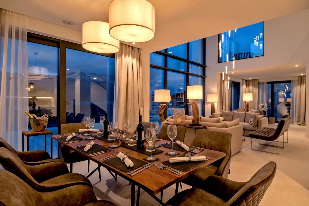 Open-plan dining and living room with double-height windows at Villa Opus